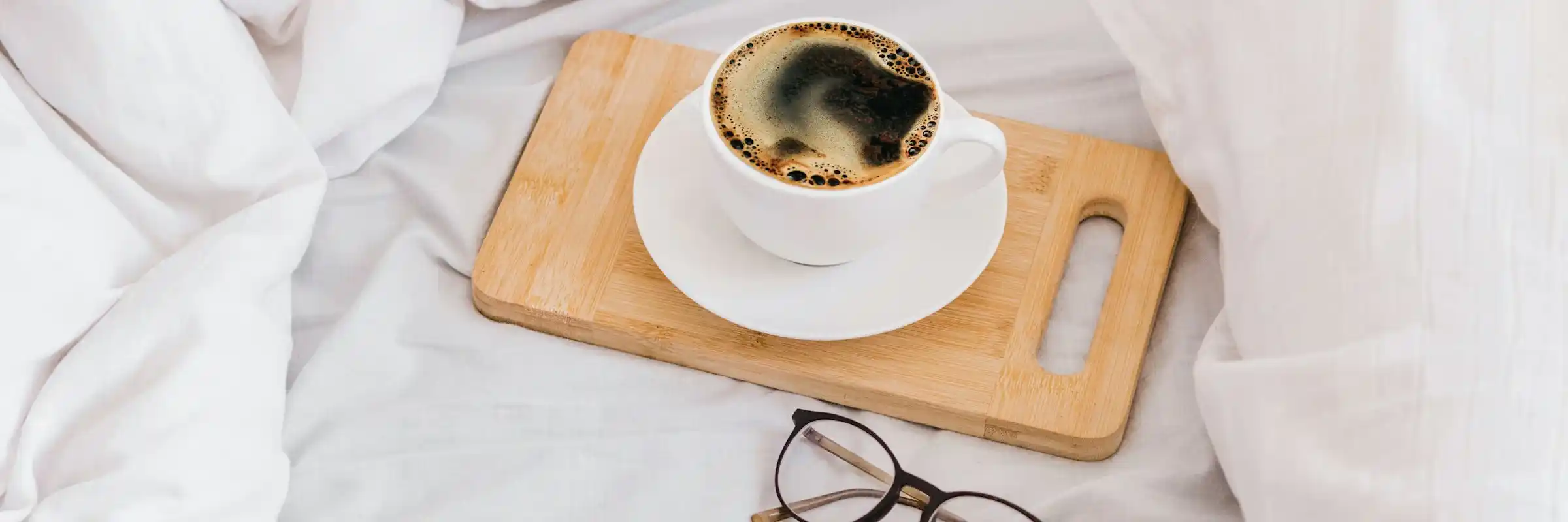 Sahuarita Mission apartment bedroom styled with coffee and reading glasses on bed